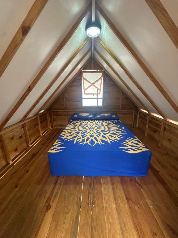 a room with a blue bed in a attic at Fare Vai Uteute in Uturoa