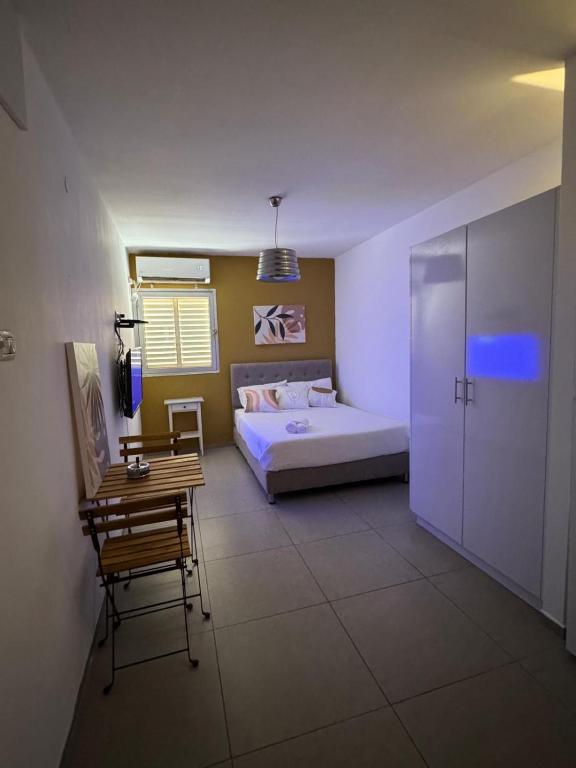 a bedroom with a bed and a table and a chair at מגדל חי 1 in Eilat