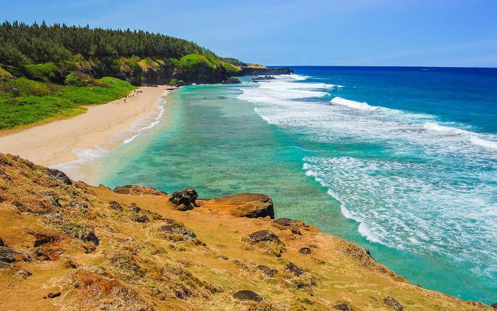 a view of a beach with rocks and the ocean at Gris Gris Apartment in Souillac