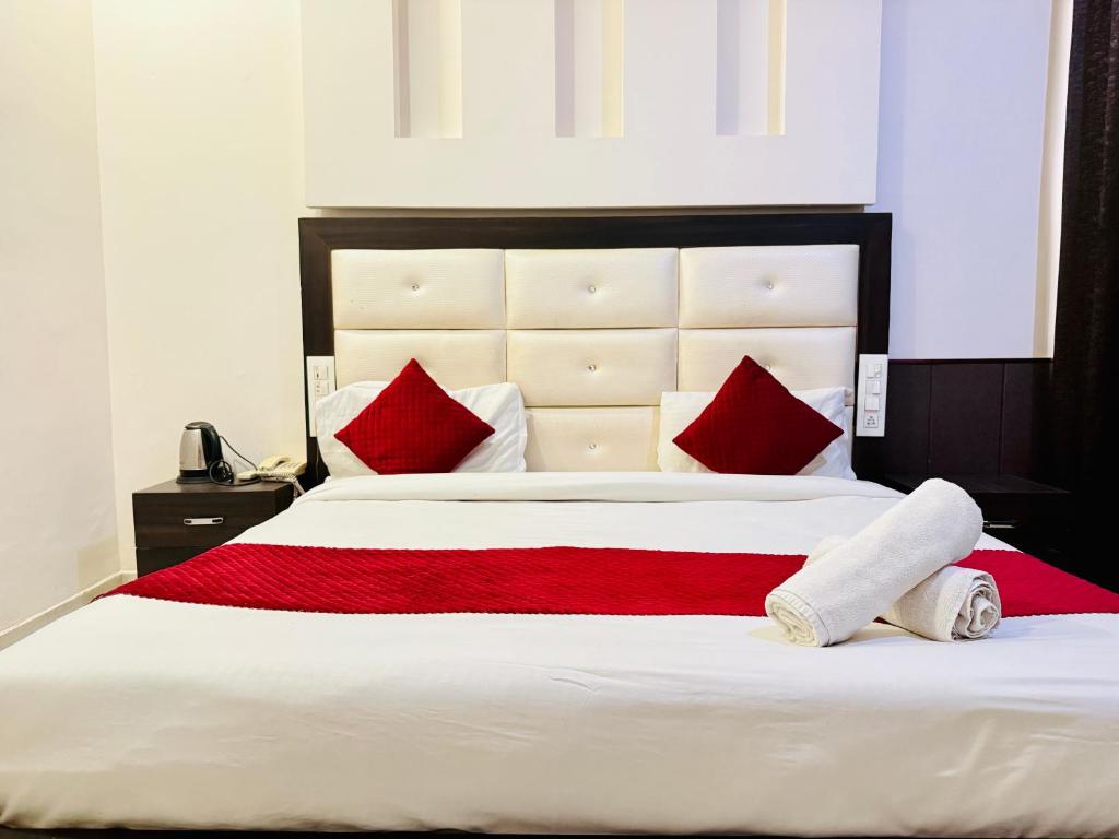 a bedroom with a large bed with red pillows at WooibHotels Yogasthali Tapovan in Rishīkesh