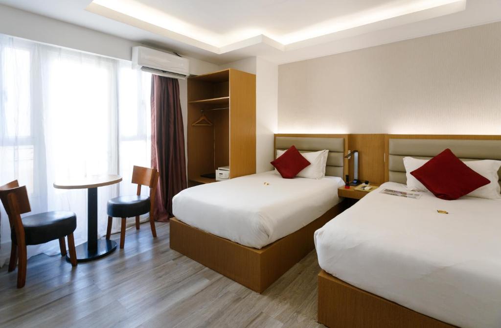 a hotel room with two beds and a table at LivStudios Manila Bay in Manila