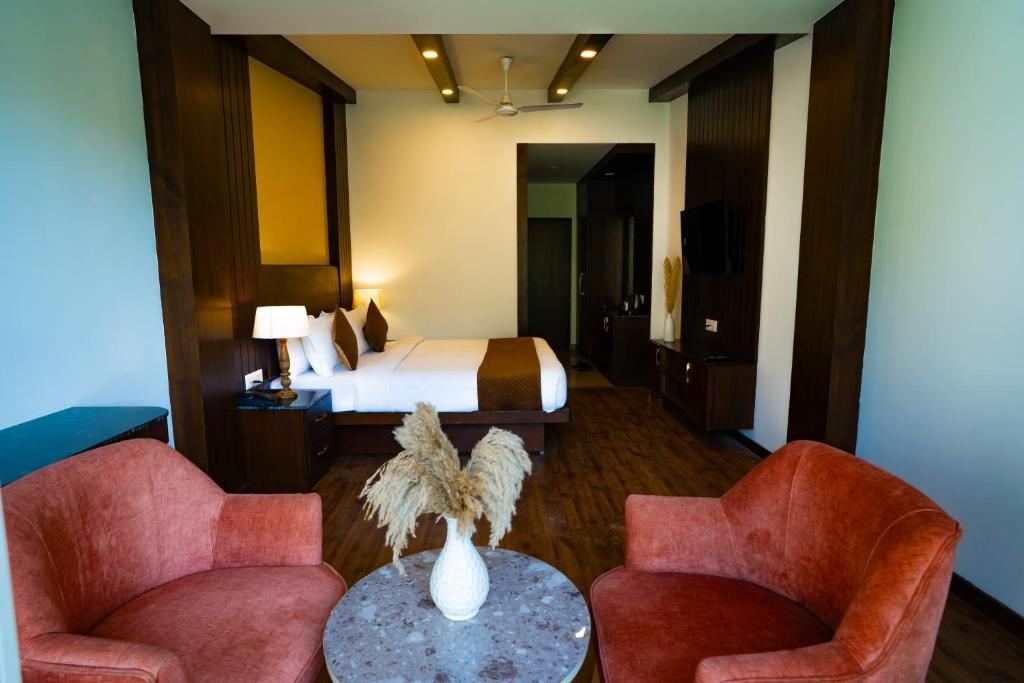 Habitación de hotel con cama, 2 sillas y mesa en Hotel White Flower, en Jāmb