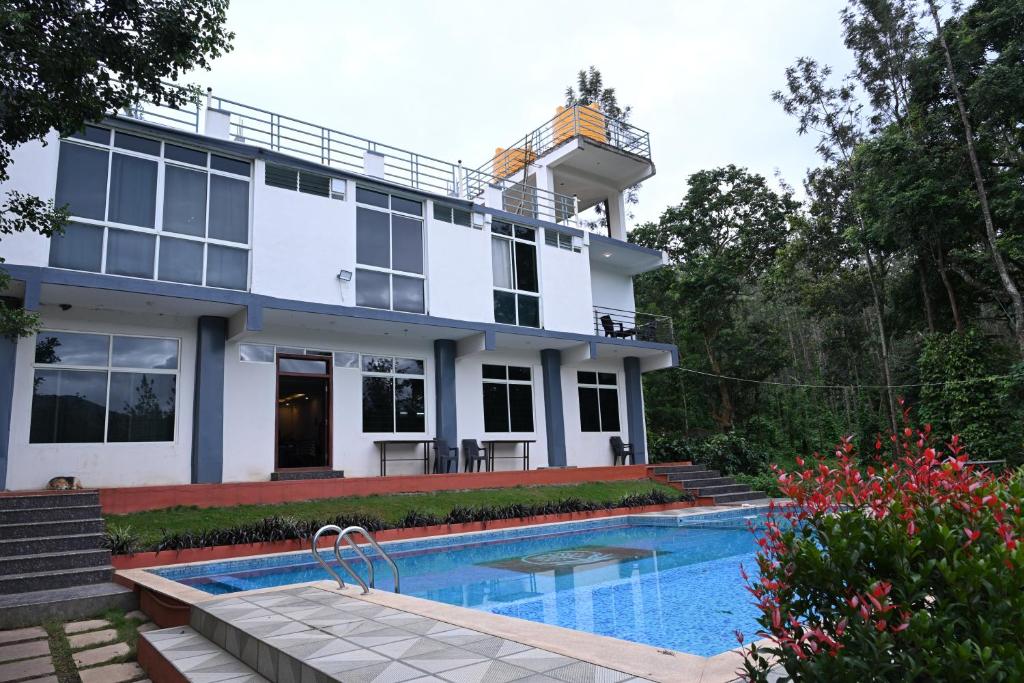 a house with a swimming pool in front of it at The Nature's Nest in Attigundi