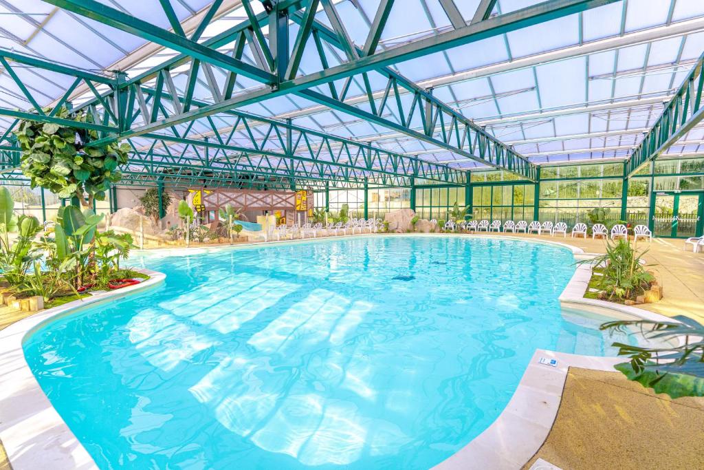 a large swimming pool with a glass ceiling at Camping Le Parc de Paris in Villevaudé