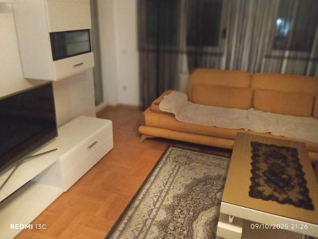 a living room with a couch and a television at FushKosov in Kosovo Polje