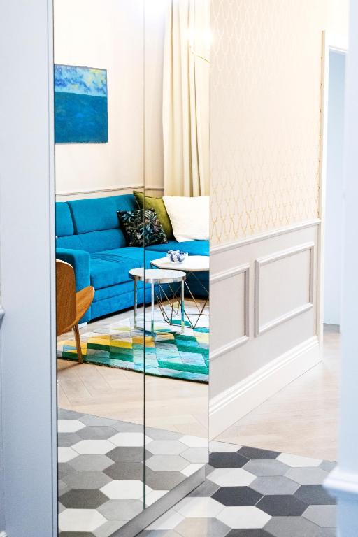 Una sala de estar con un sofá azul y una mesa. en Maya's Flats & Resorts 44 - 3 Rooms Apartment On C, en Gdansk