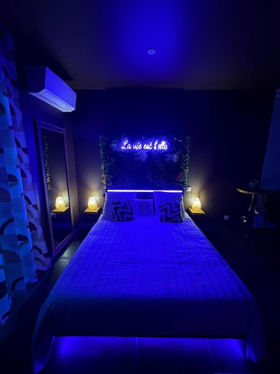 a blue bedroom with a large bed in a room at Appartement Romantique Exceptionnel in Lorette