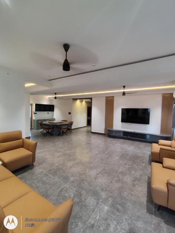 a living room with couches and a table and a flat screen tv at Shreshtam Apart Hotel, Kondapur in Lingampalli