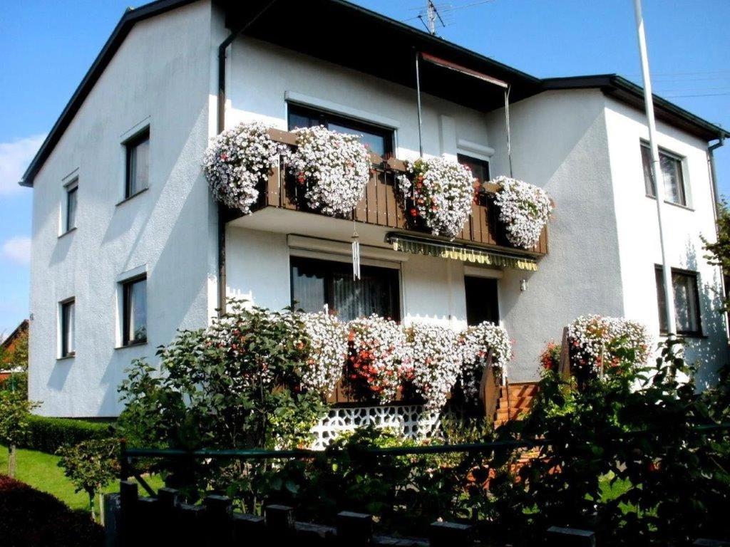 un bâtiment blanc avec des pots de fleurs sur un balcon dans l'établissement Ferienwohnung Haus Michel, 90 Qm, à Uhldingen-Mühlhofen