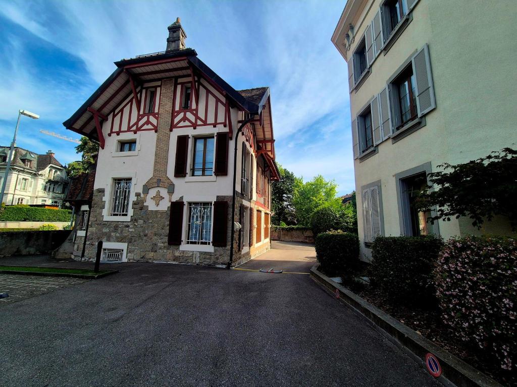 a house with a gambrel roof on a street at Pavillon Bon Rivage in La Tour-de-Peilz