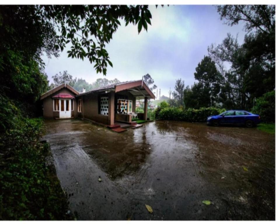 a flooded parking lot with a car parked next to a building at The Groot in Ooty