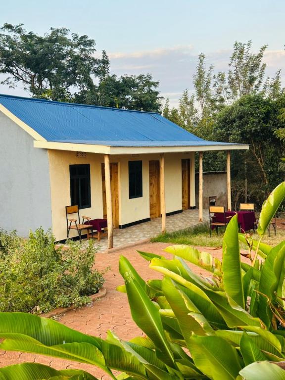 a small white house with a blue roof at J&T Homestay in Karatu