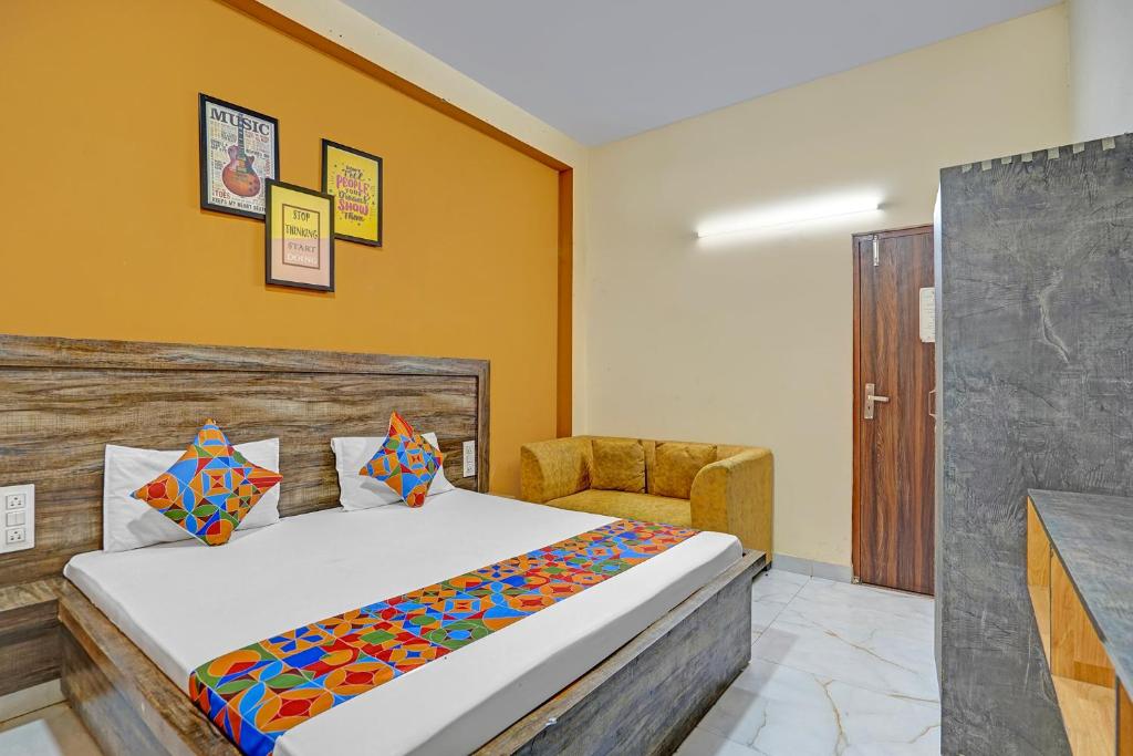 a bedroom with a bed and a chair at FabHotel Galaxy Greno Celebration in Greater Noida