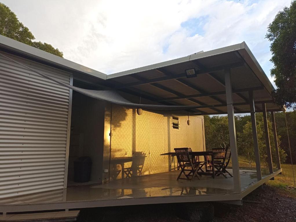 awning over a patio with a table and chairs at Studio à Tamaon 