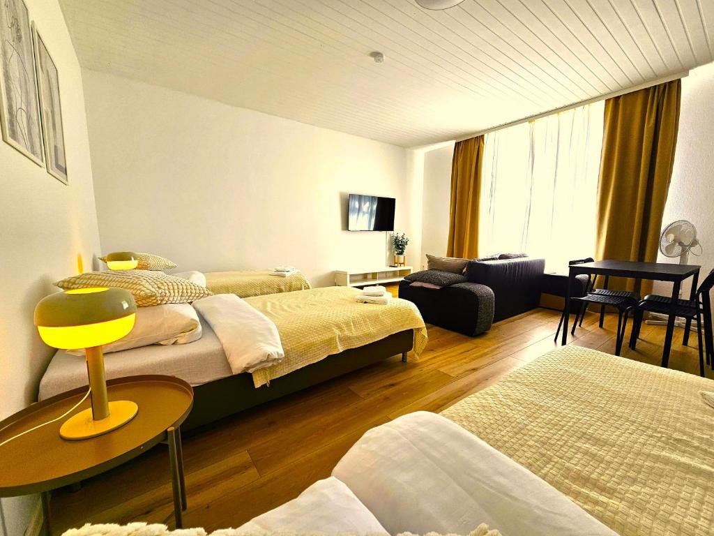 Hotel Airport-Messe Apartments, a bedroom with two beds and a living room at Airport-Messe Apartments in Düsseldorf