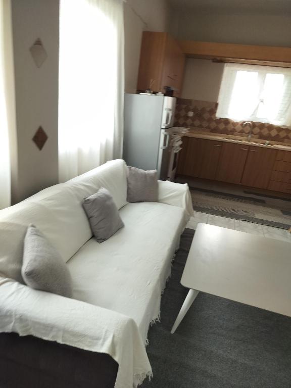 a living room with a white couch and a table at Stylish Modern Flat in Pyrgos near Olympia in Pýrgos