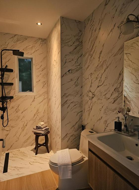 a bathroom with a sink and a toilet and a tub at Charly Apartment - 2BR Seaview Cozy Apartment in Ban Ko Khwan