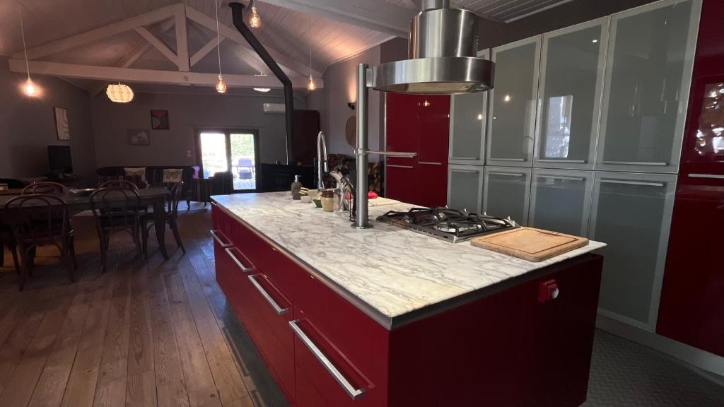 a kitchen with a counter top and a stove top oven at Maison Chaleureuse avec Terrasse Privée in Valréas
