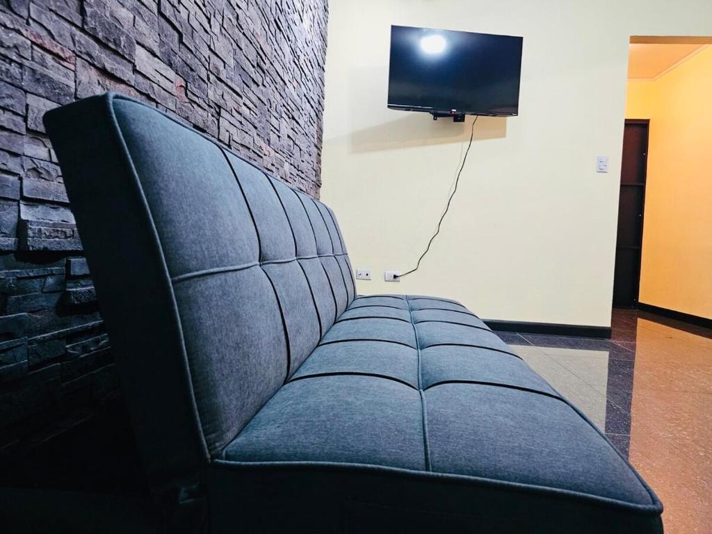 un sofá de cuero negro en una habitación con TV en Beautiful Entire House, en San Pedro
