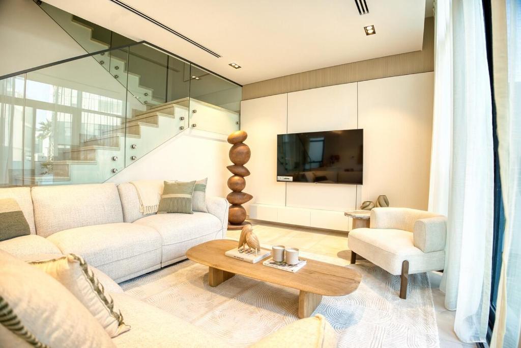 ein Wohnzimmer mit Sofa und Tisch in der Unterkunft Luxury 3BR Villa with Maid Room & Private Beach Access in Ras al Khaimah