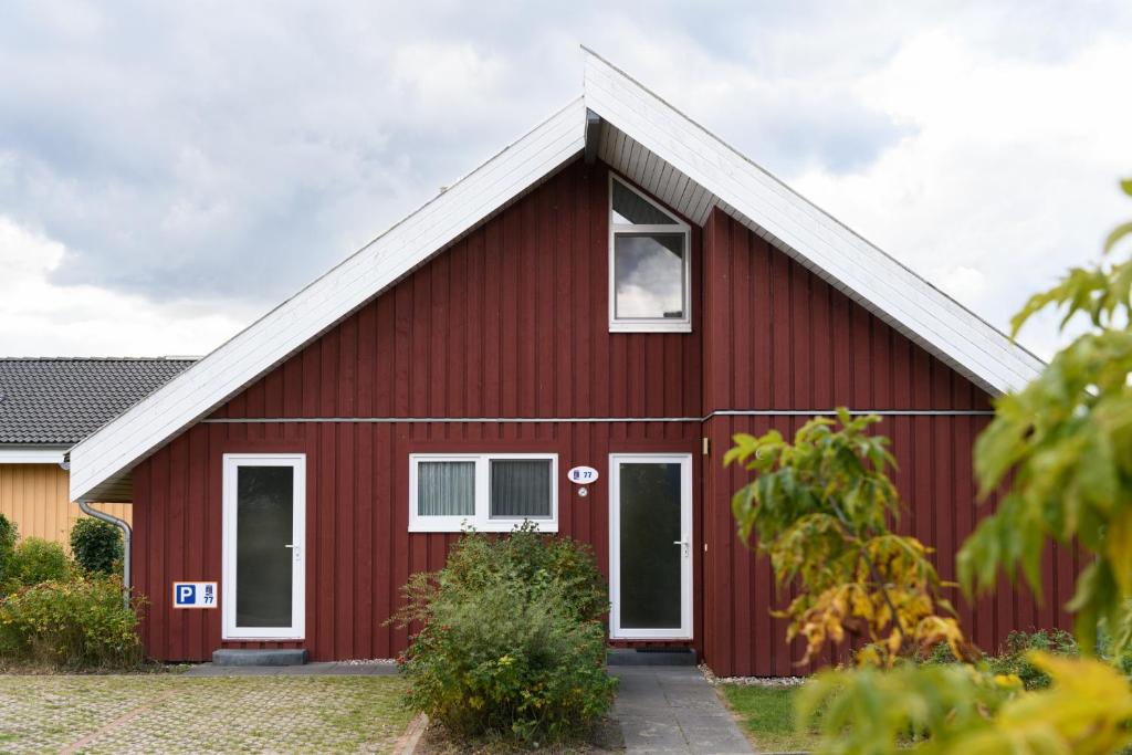 a red barn with a white roof at Seeschwalbe Classic 77 in Rechlin