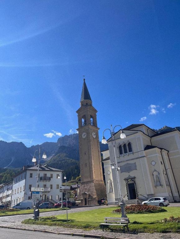 a building with a tower with a clock on it at Mansardina Il Nido in Padola