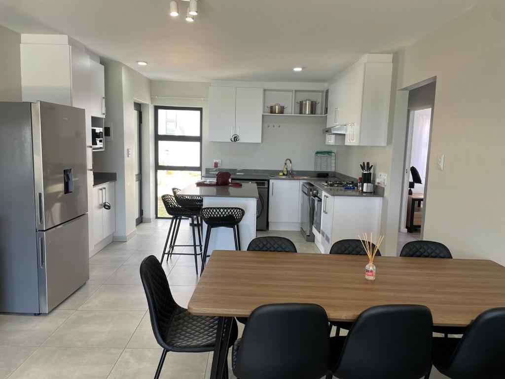 een keuken en eetkamer met een tafel en stoelen bij Coastal Charm St Francis Bay in Vosburg