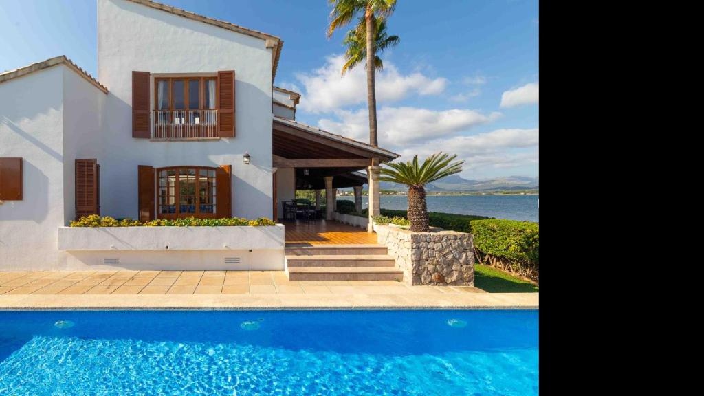 a villa with a swimming pool in front of a house at Es Mollet de Barcares in Alcudia