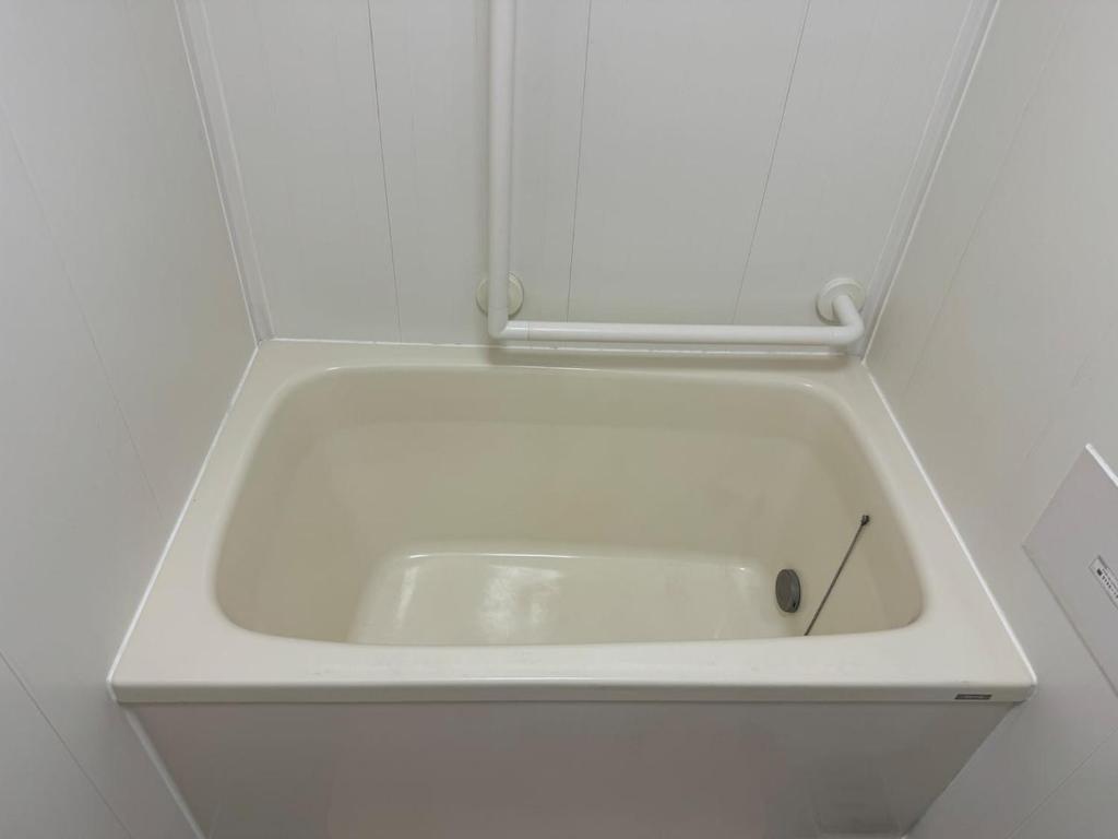 eine weiße Badewanne in einer weißen Wand in der Unterkunft 6 minutes to Shinjuku, 10 minutes to Shibuya, accommodating 6 people in Tokio