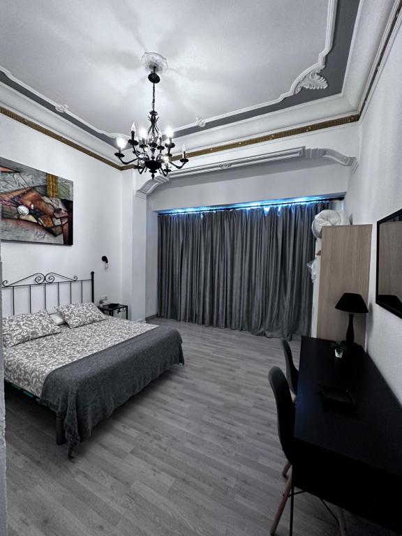 a bedroom with a bed and a desk and a piano at Home Turia Pio Apartamento de 3 habitaciones in Valencia