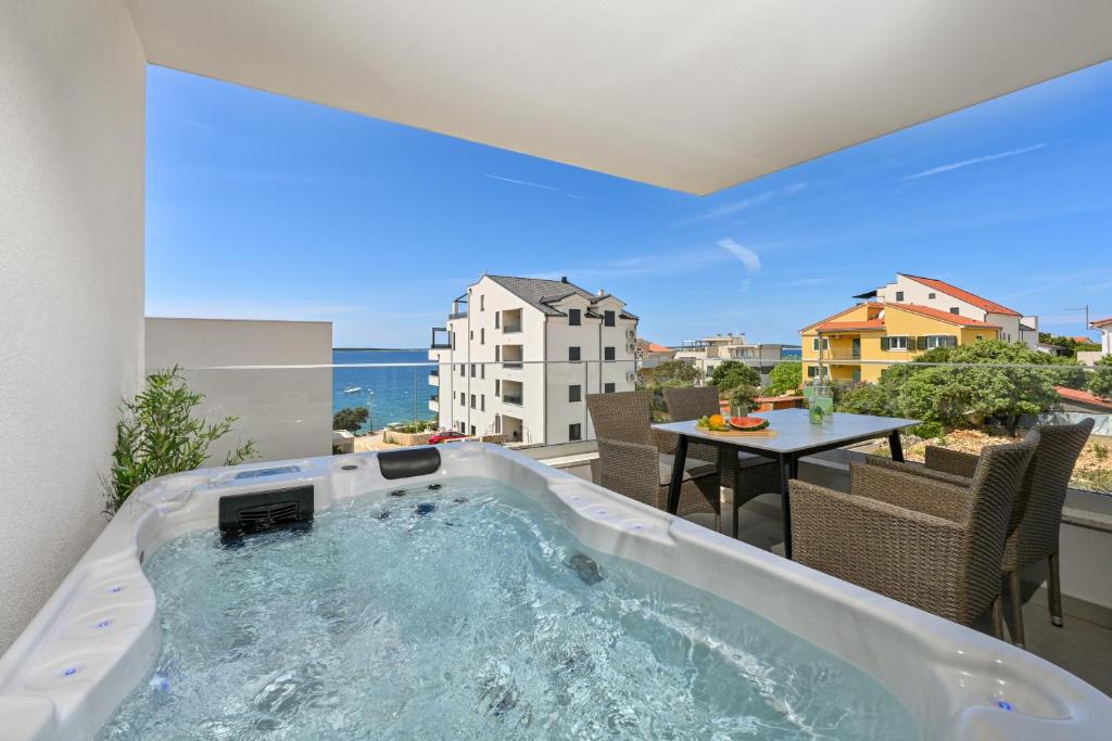 een hot tub op een balkon met een tafel bij Apartment Amarilis in Mandre