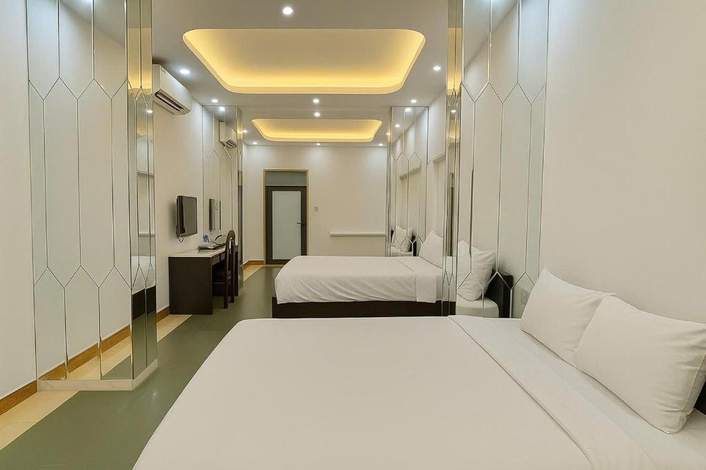Thôn Lại ThêにあるLion Homestay Huếのベッドが2つと鏡があるホテルの部屋