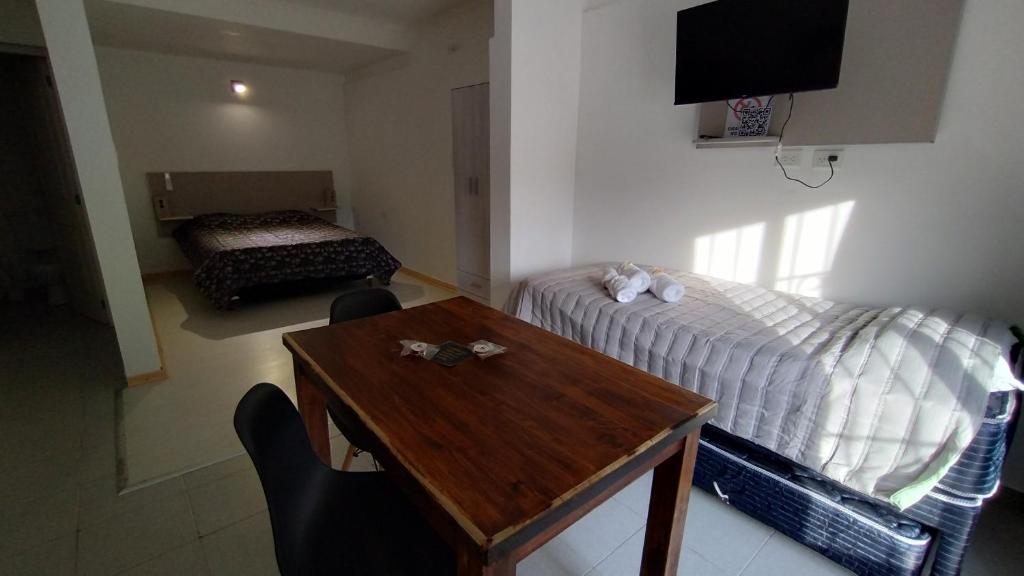 Habitación con cama, mesa y cama en Loft San Lorenzo, en Bahía Blanca