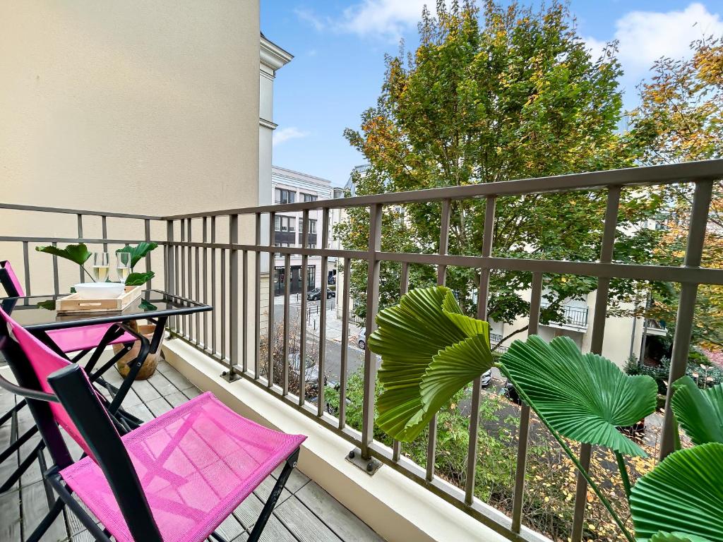 een balkon met een tafel en stoelen en een plant bij Sweet Dream Chessy-Near Disney, Parking privée in Chessy