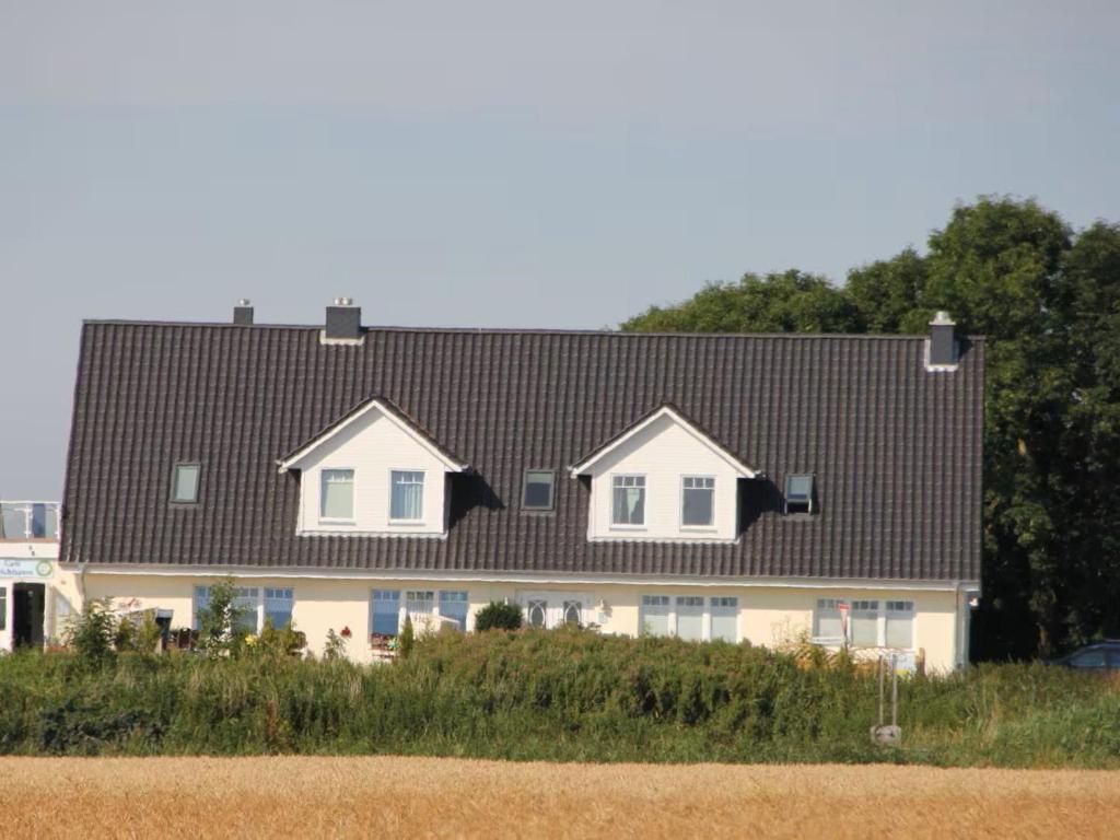 GalmsbüllにあるFerienwohnungen Deichtraumの黒屋根の家