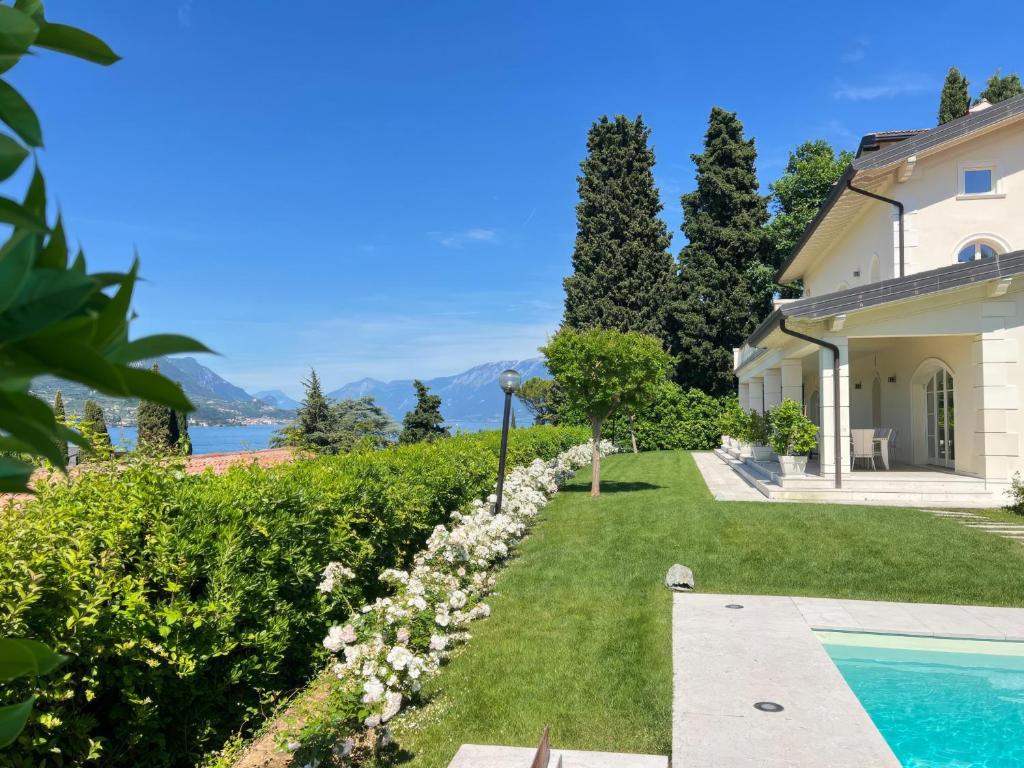 a house with a garden and a swimming pool at Villa Aria in San Felice del Benaco