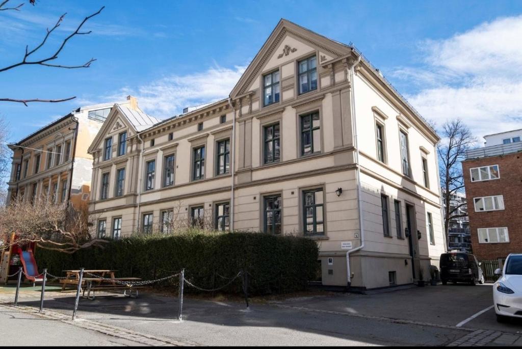 een groot wit gebouw op een parkeerplaats bij Tranquility near everything - Majorstua in Oslo