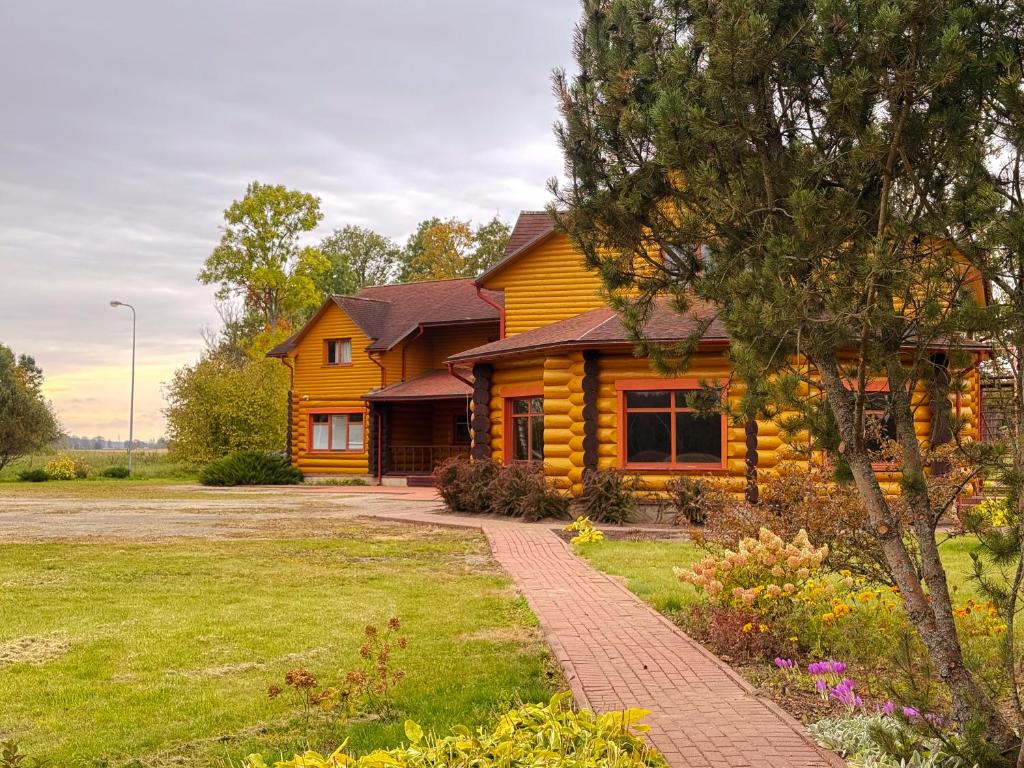 a log house with a driveway in front of it at Saules sēta in Lazdenieki