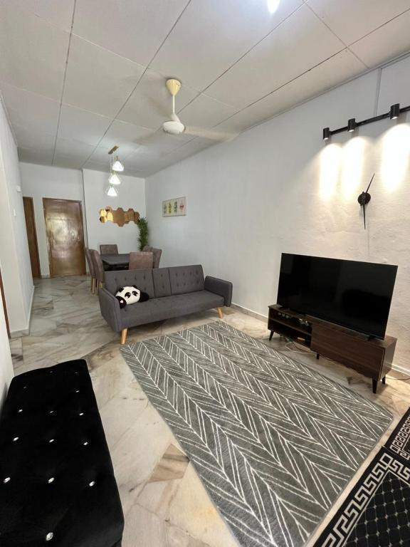 a living room with a couch and a flat screen tv at Mus Lim Homestay Aqil Bandar Puncak Alam in Bandar Puncak Alam