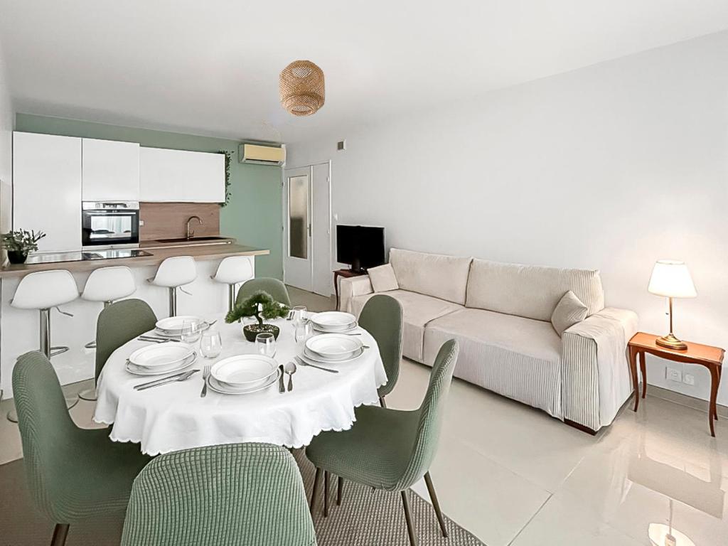 a living room with a table and a couch at Évasion douce en centre-ville de St-Raphaël in Saint-Raphaël
