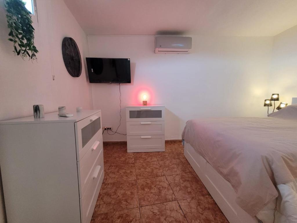 une chambre avec un lit et une commode avec une télévision dans l'établissement René, à Los Realejos