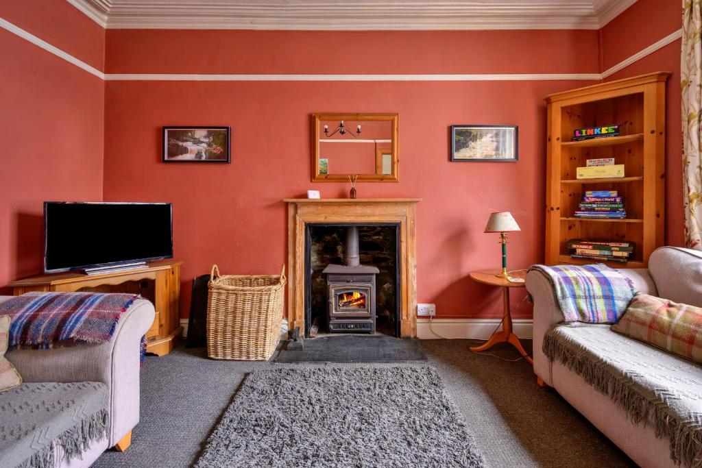 a living room with a fireplace and a tv at Finest Retreats - Bod Gwynedd in Penmachno