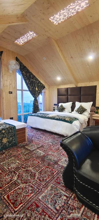 a large bedroom with two beds and a rug at Countryside Cottage Gulmarg in Tangmarg