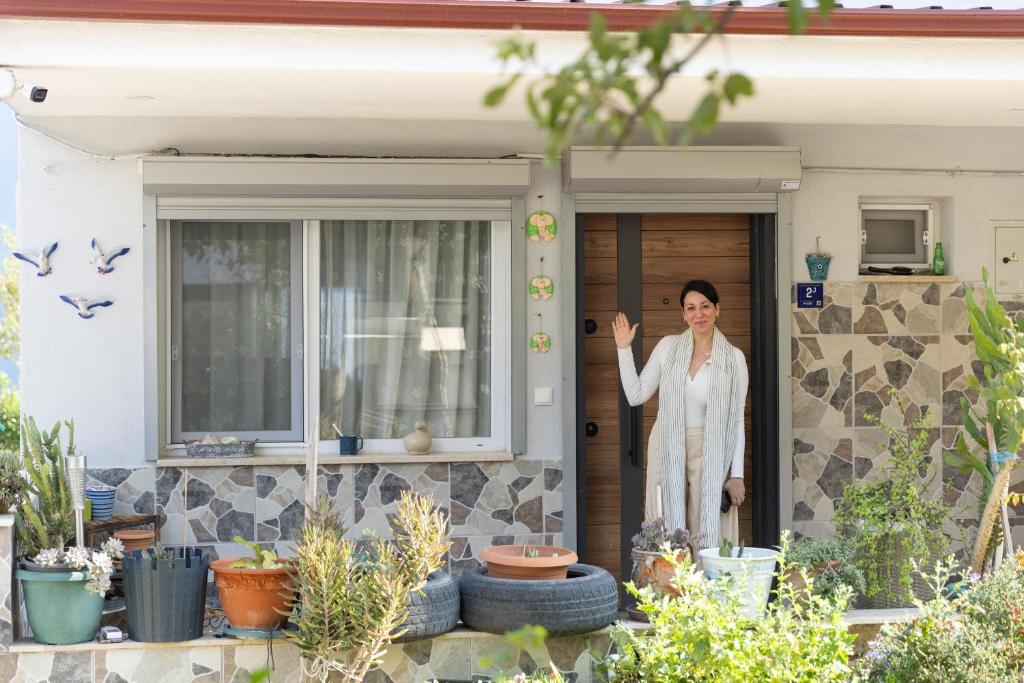 une femme debout sur la porte d'une maison dans l'établissement Sisi's Holiday Houses - Kusadasi, à Kusadası