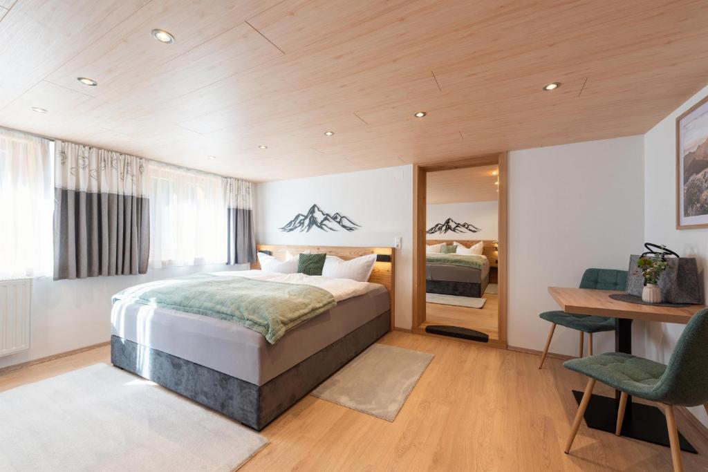 a bedroom with a bed and a desk and a table at Apartment Simone in Klösterle am Arlberg