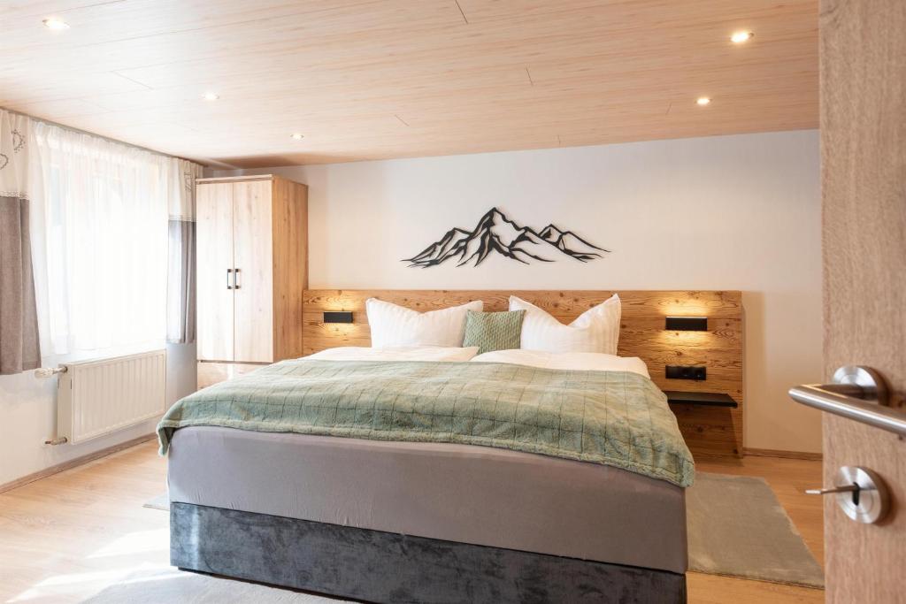 a bedroom with a large bed with mountains on the wall at Apartment Simone in Klösterle