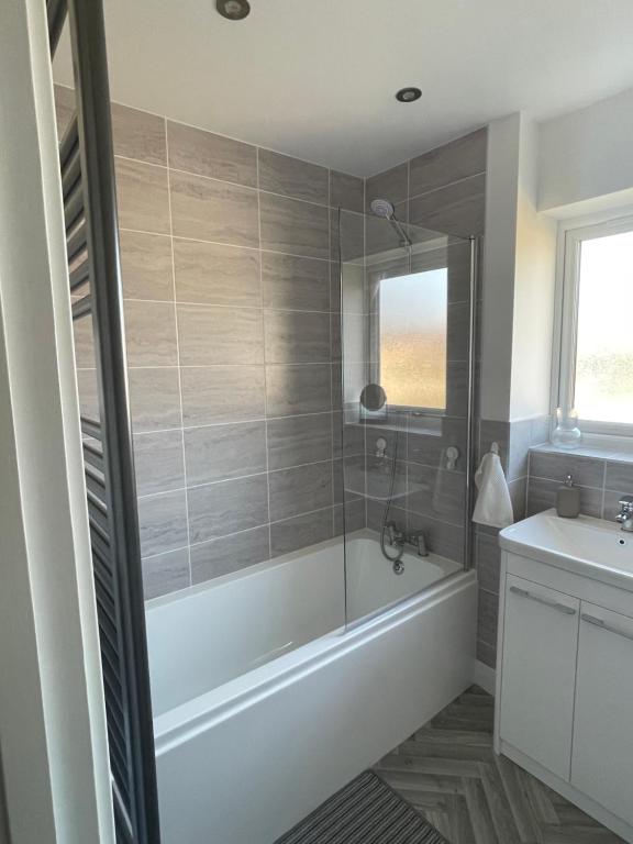 een badkamer met een bad en een wastafel bij Sleaford Luxury Country Stay in Sleaford