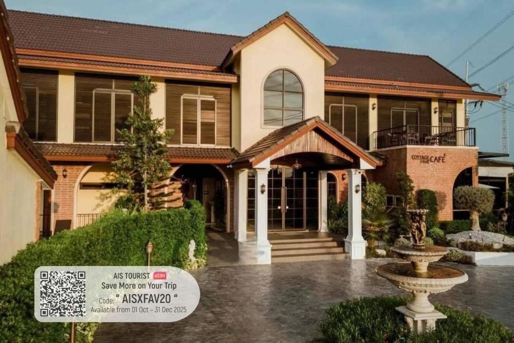 uma casa com uma placa na frente em CottagePine Rayong Resort&Cafe em Ban Ko Kloi
