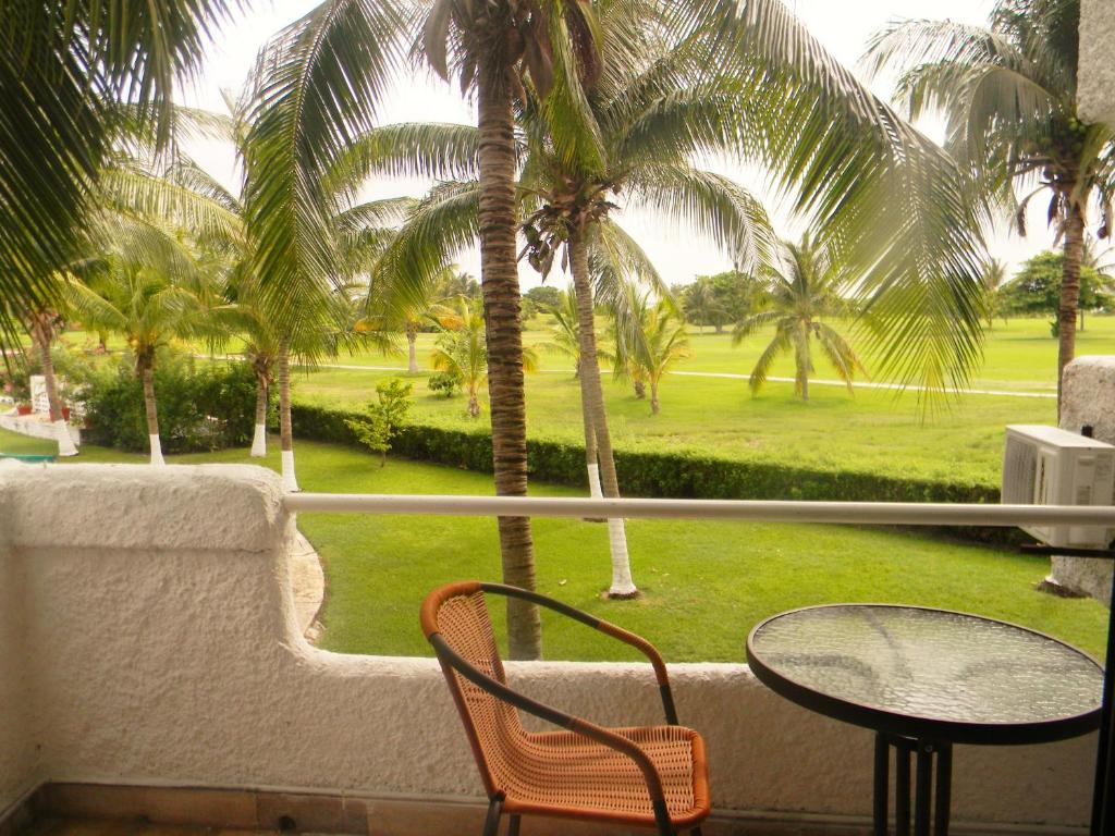 een balkon met een tafel en stoelen en palmbomen bij Casa Pok Tapok in Cancun