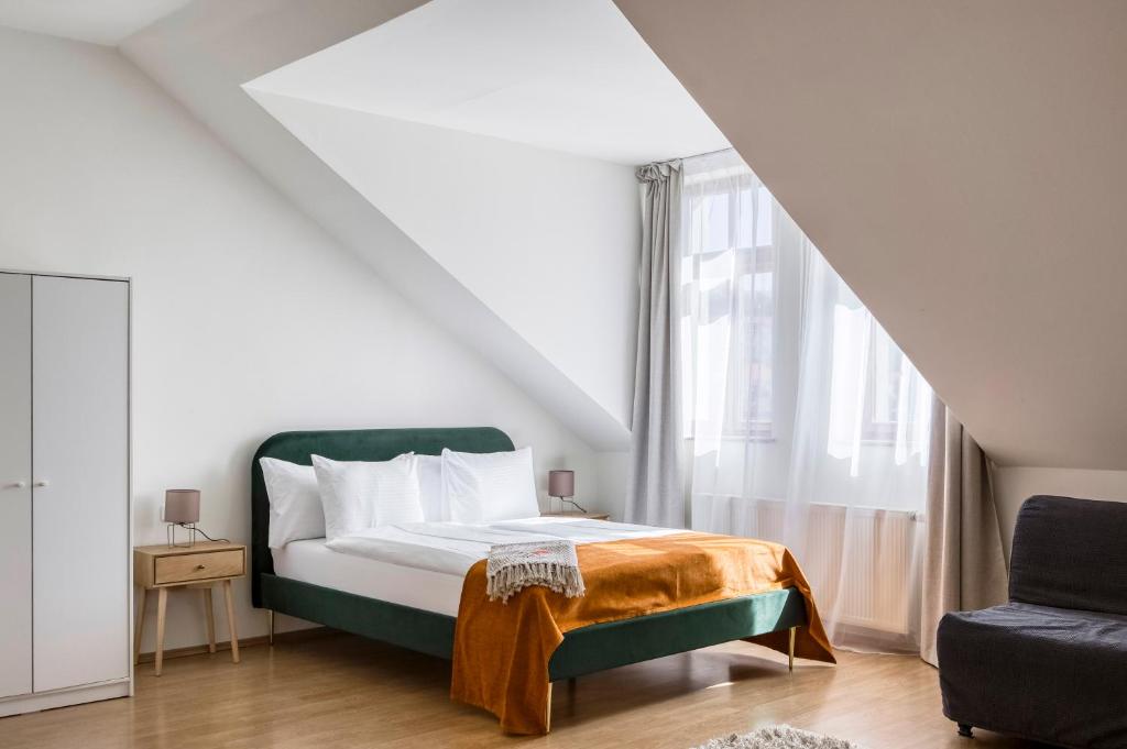 a bedroom with a green bed and a window at Anmut by Revelton in Karlovy Vary